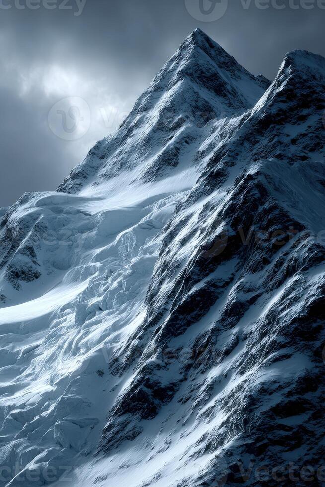 Snowy mountain peaks under dramatic cloudy sky in winter photo