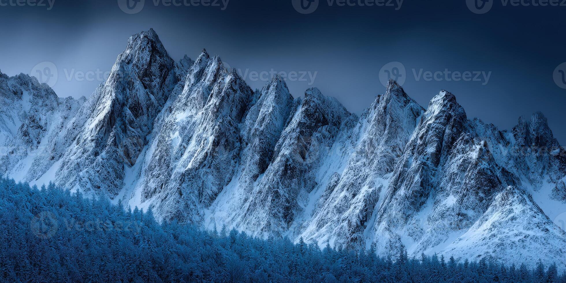 Snow-covered mountains under a dramatic dark sky at dusk photo