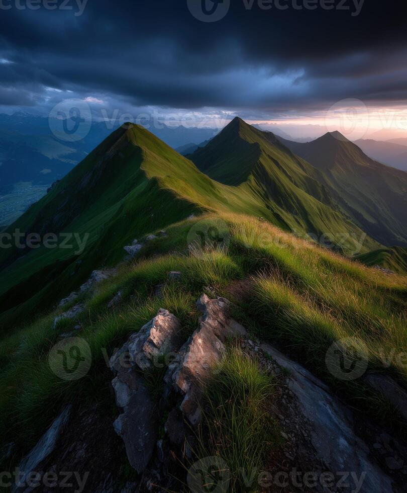 Mountain peaks bathed in sunset glow under dark clouds photo