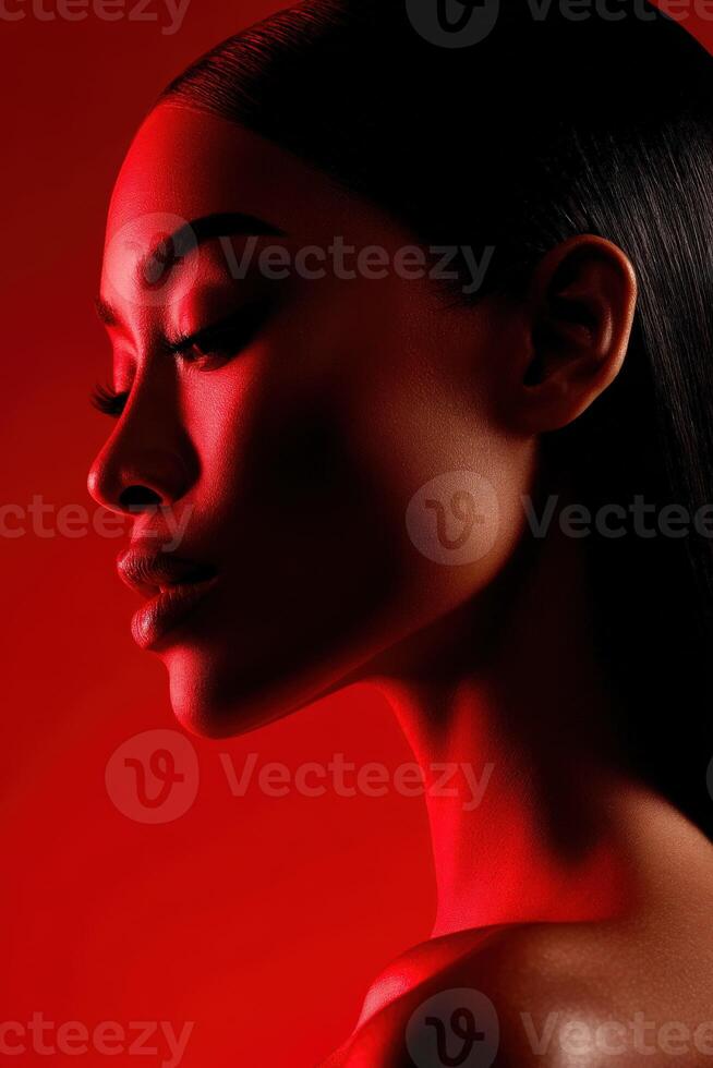 Elegant profile of a woman with dramatic red lighting in a studio setting photo
