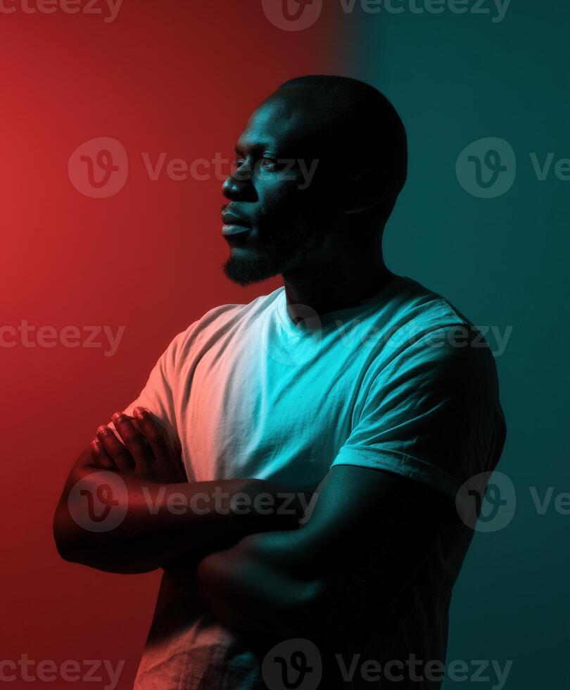 Man in t-shirt poses thoughtfully against colorful backdrop in studio lighting photo