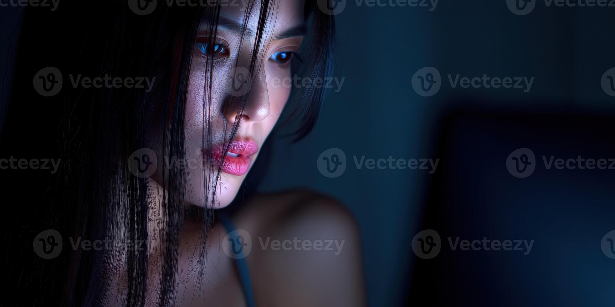 Woman focused on screen in dim lighting during nighttime photo