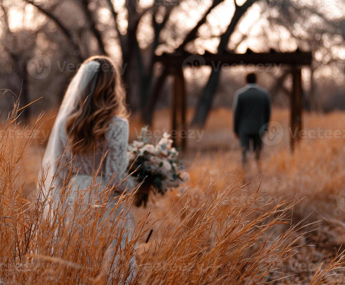 Couple exchanging vows in a golden field during sunset photo