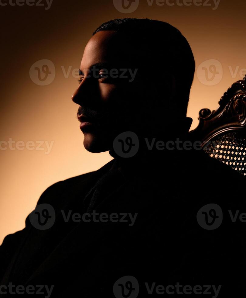 A man in a suit sitting in a chair photo