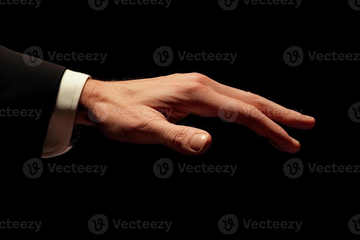 Elegant hand gesture of a businessman reaching out against a dark background photo