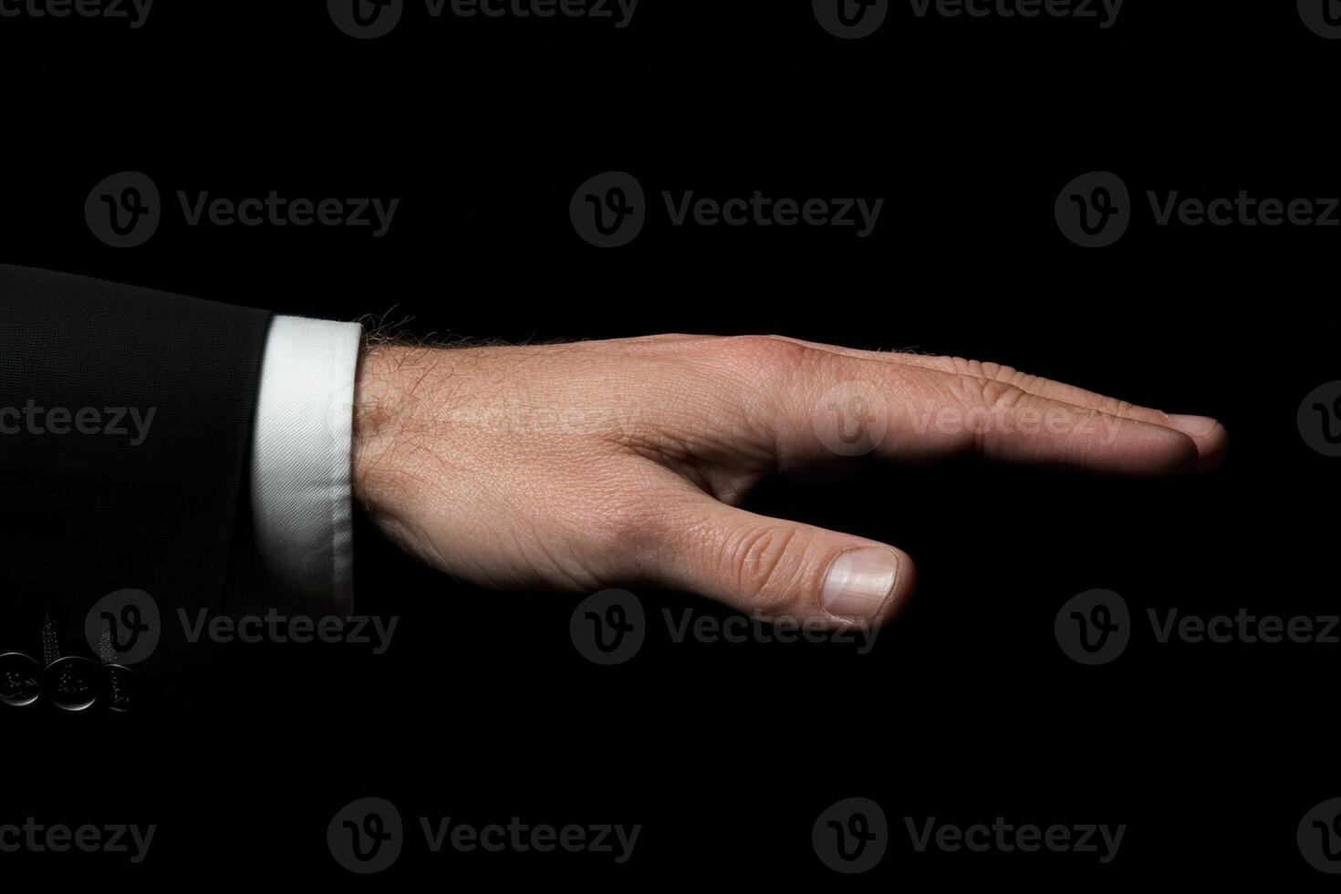Elegant hand gesture in a formal suit against a dark background, conveying authority and poise photo