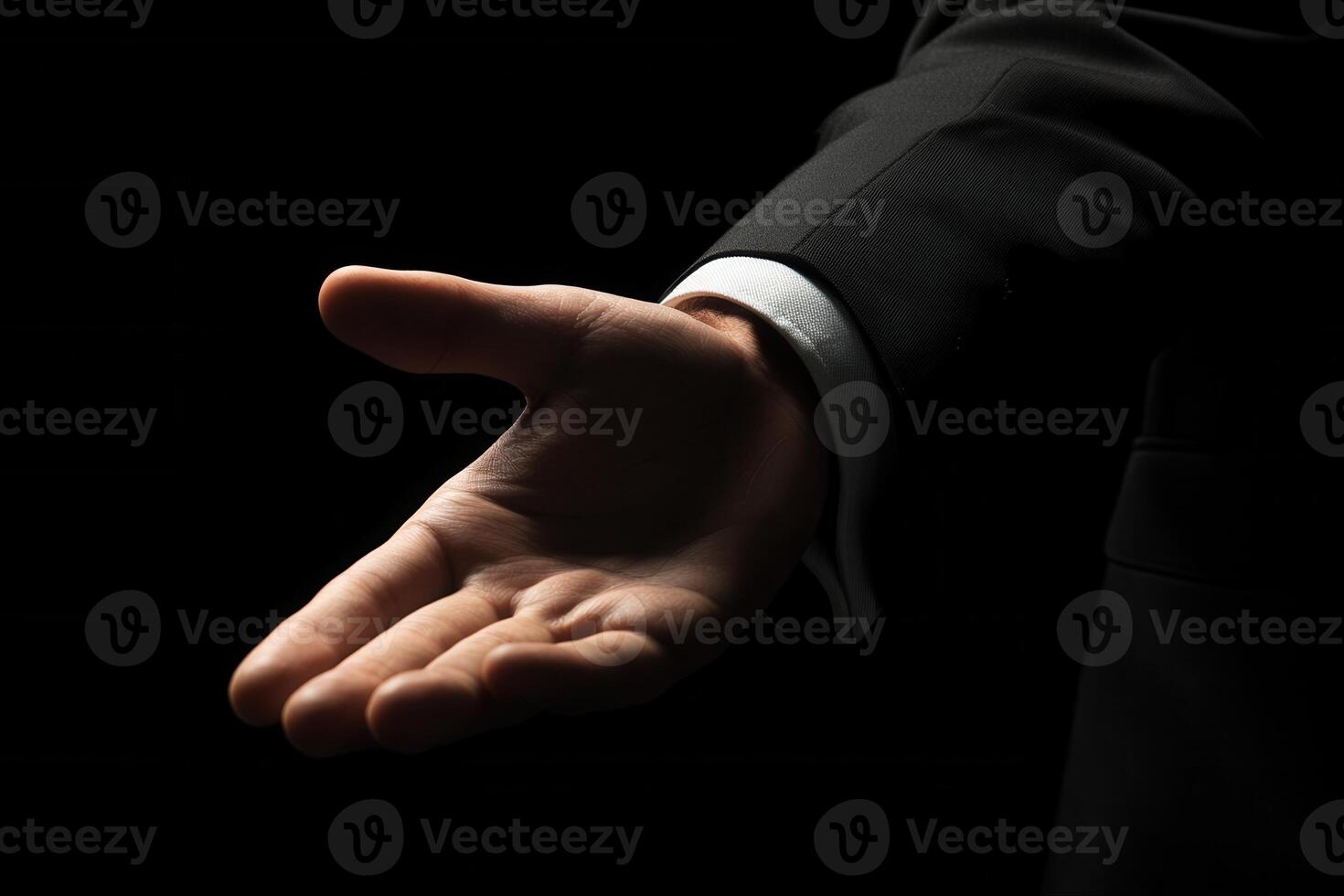 Elegant hand gesture in a formal suit against a dark background, conveying invitation or greeting photo