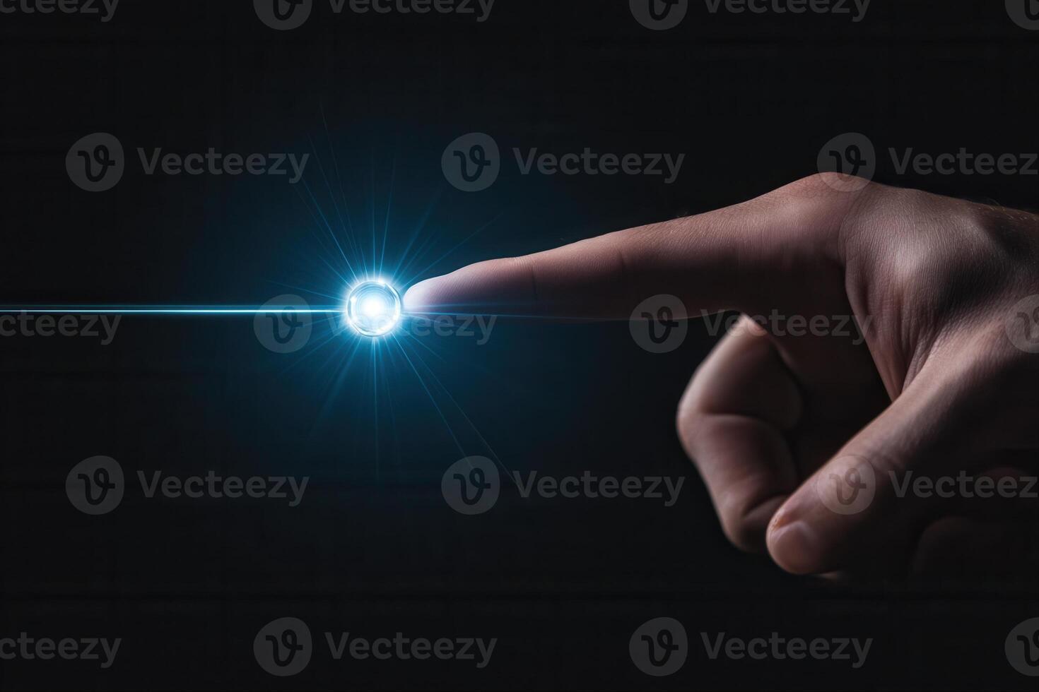 A human finger reaching out to touch a glowing orb of light against a dark background photo