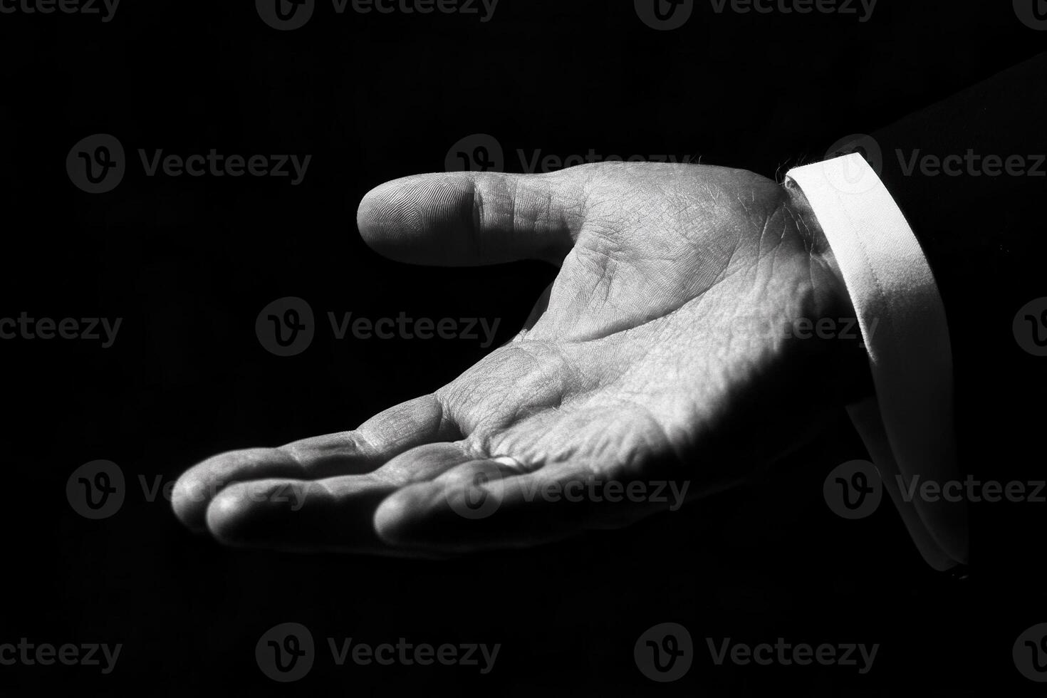 Elegant open hand gesture in black and white against a dark background, suggesting invitation photo