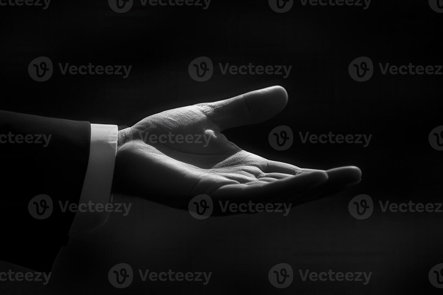 Elegant black and white hand gesture symbolizing offering or assistance in a dramatic light photo