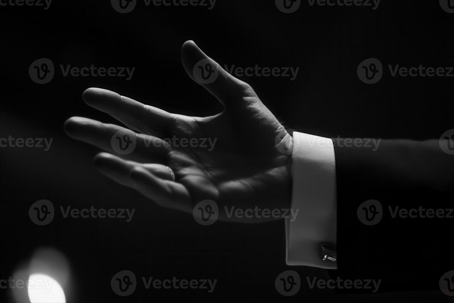 Elegant hand gesture in a dimly lit setting, suggesting a moment of communication or invitation photo