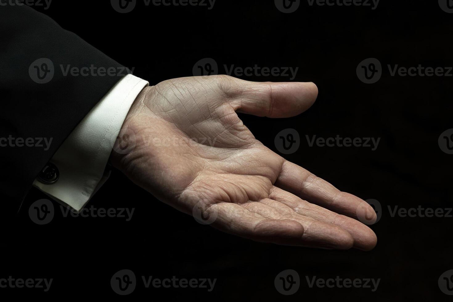 Elegant hand gesture in a formal attire against a dark background, inviting interaction photo