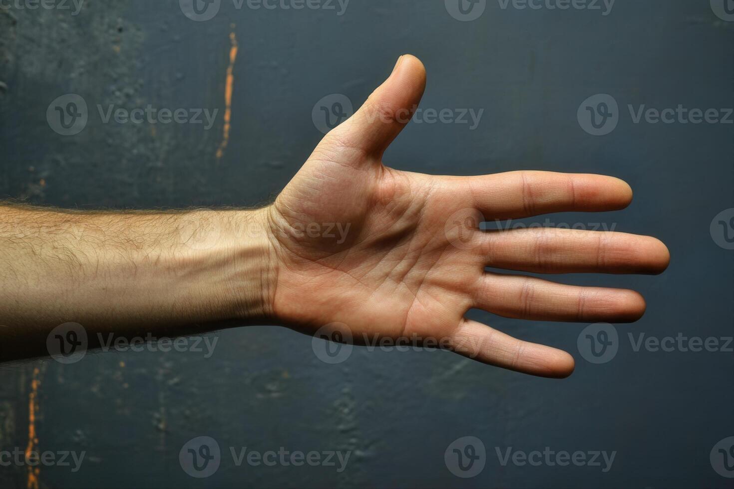 Close-up of a human hand with fingers extended against a textured blue background photo