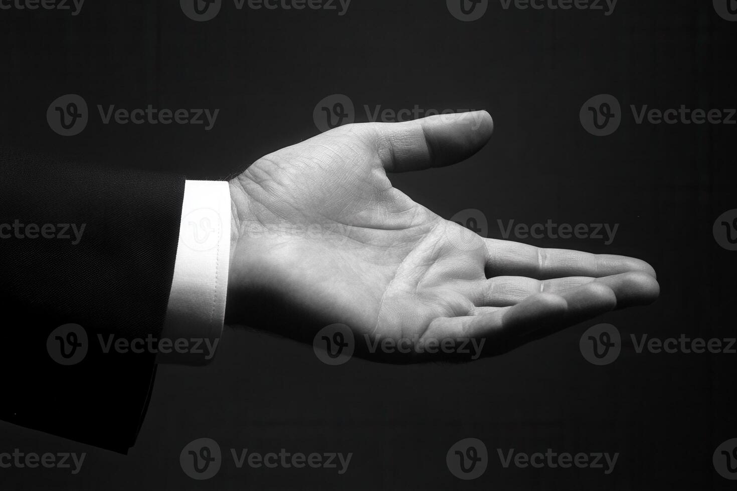 Elegant open hand gesture in formal attire against a dark background, inviting interaction photo