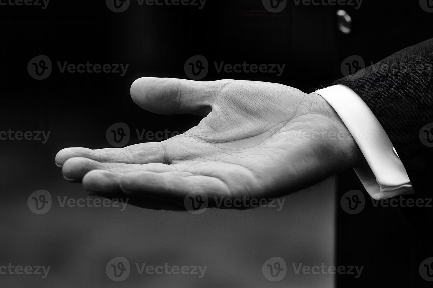 A close-up of an open hand in a formal suit, symbolizing invitation or assistance photo