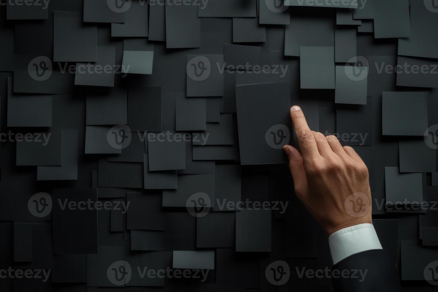 A business professional interacting with a textured black wall of blank cards, symbolizing creativity photo