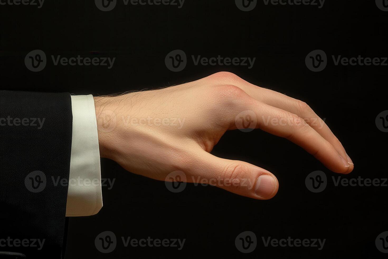 Elegant hand gesture in a formal suit against a dark background, conveying sophistication photo