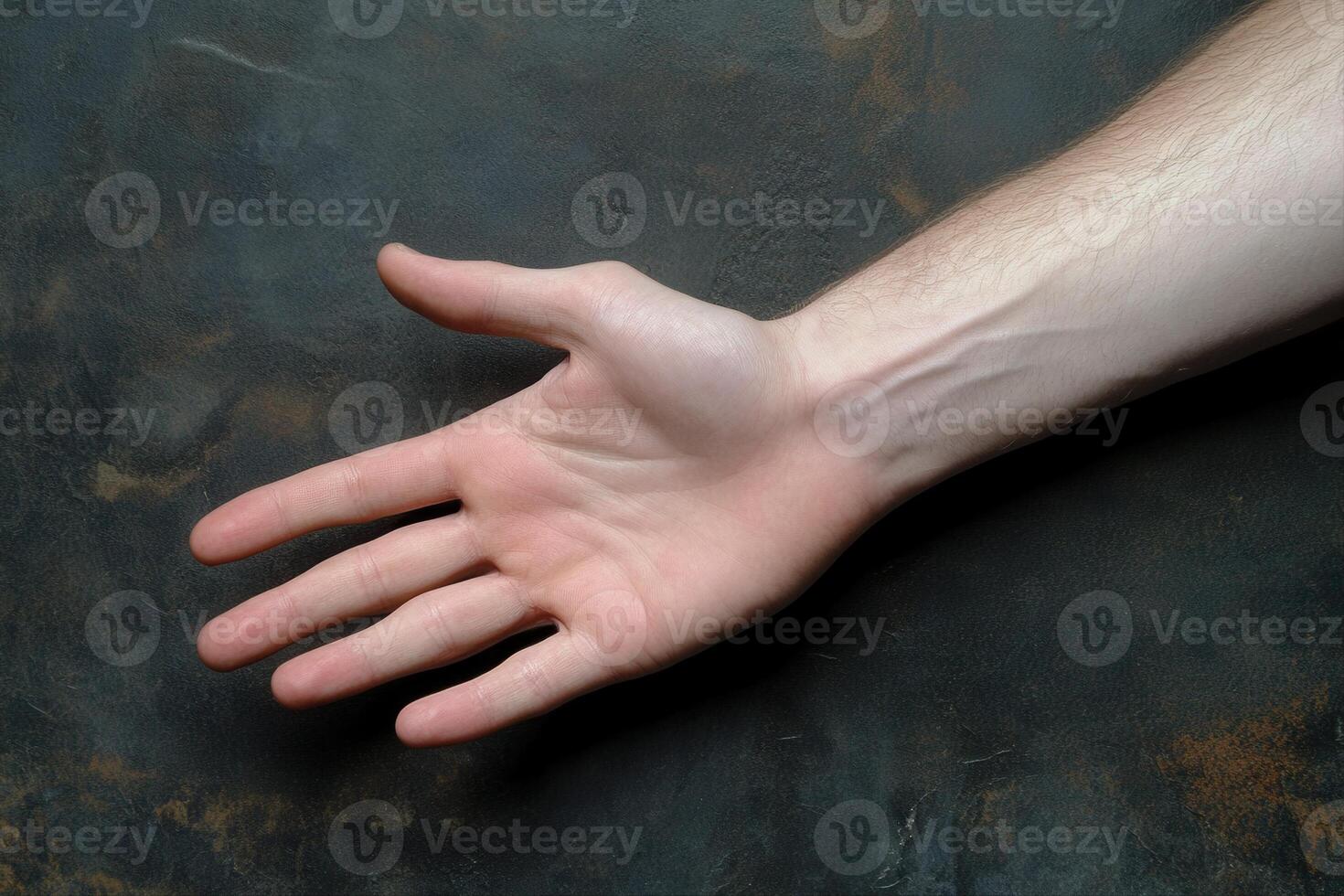 A close-up of an outstretched human hand against a textured dark background photo