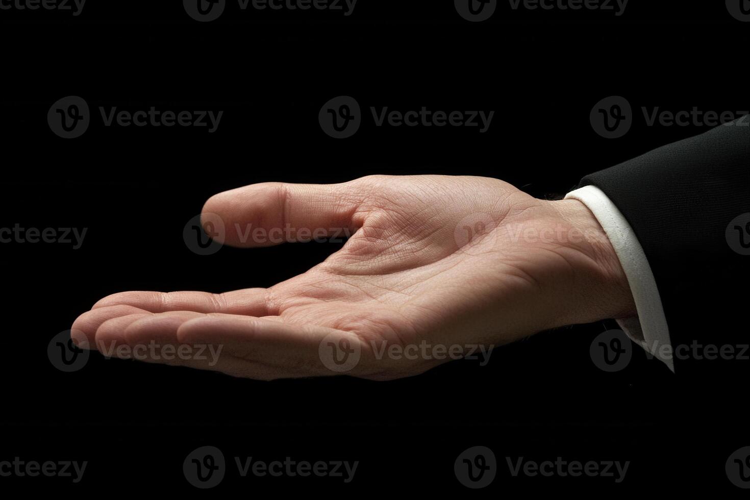 Open hand gesture in a business suit against a dark background, symbolizing opportunity photo