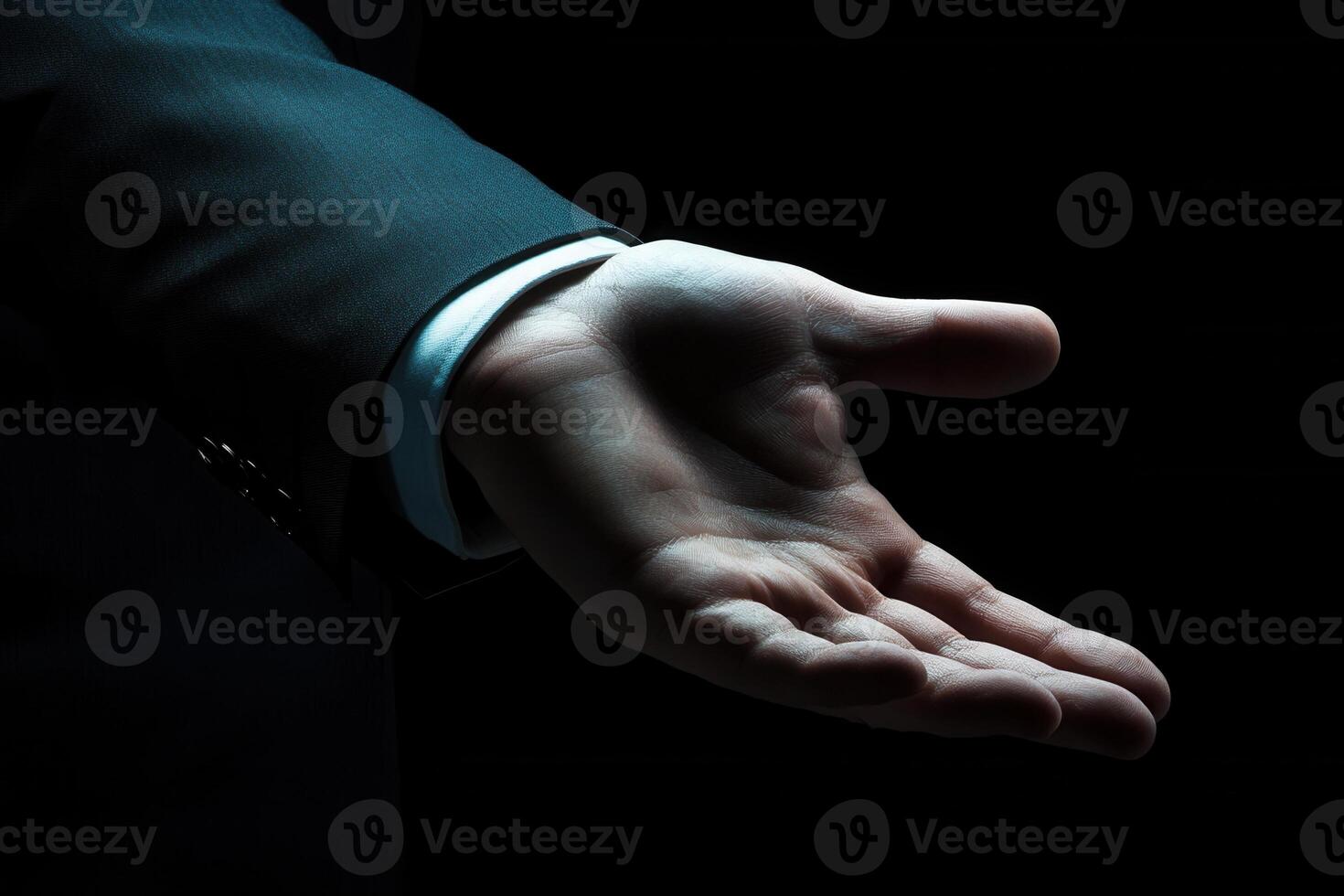 Outstretched hand in a formal suit against a dark background, symbolizing invitation photo
