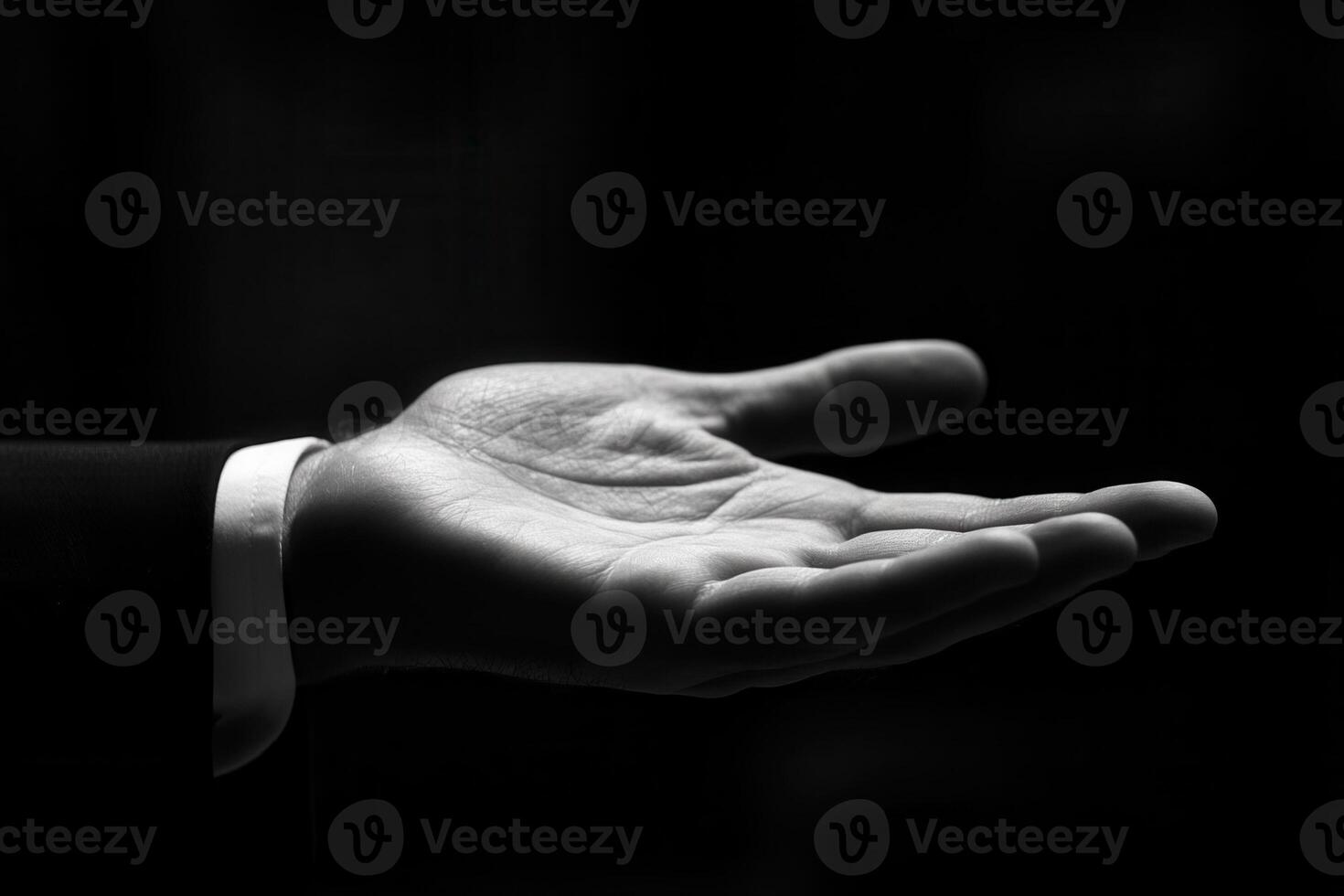 Open hand gesture in black and white, showcasing elegance and readiness in a dark setting photo