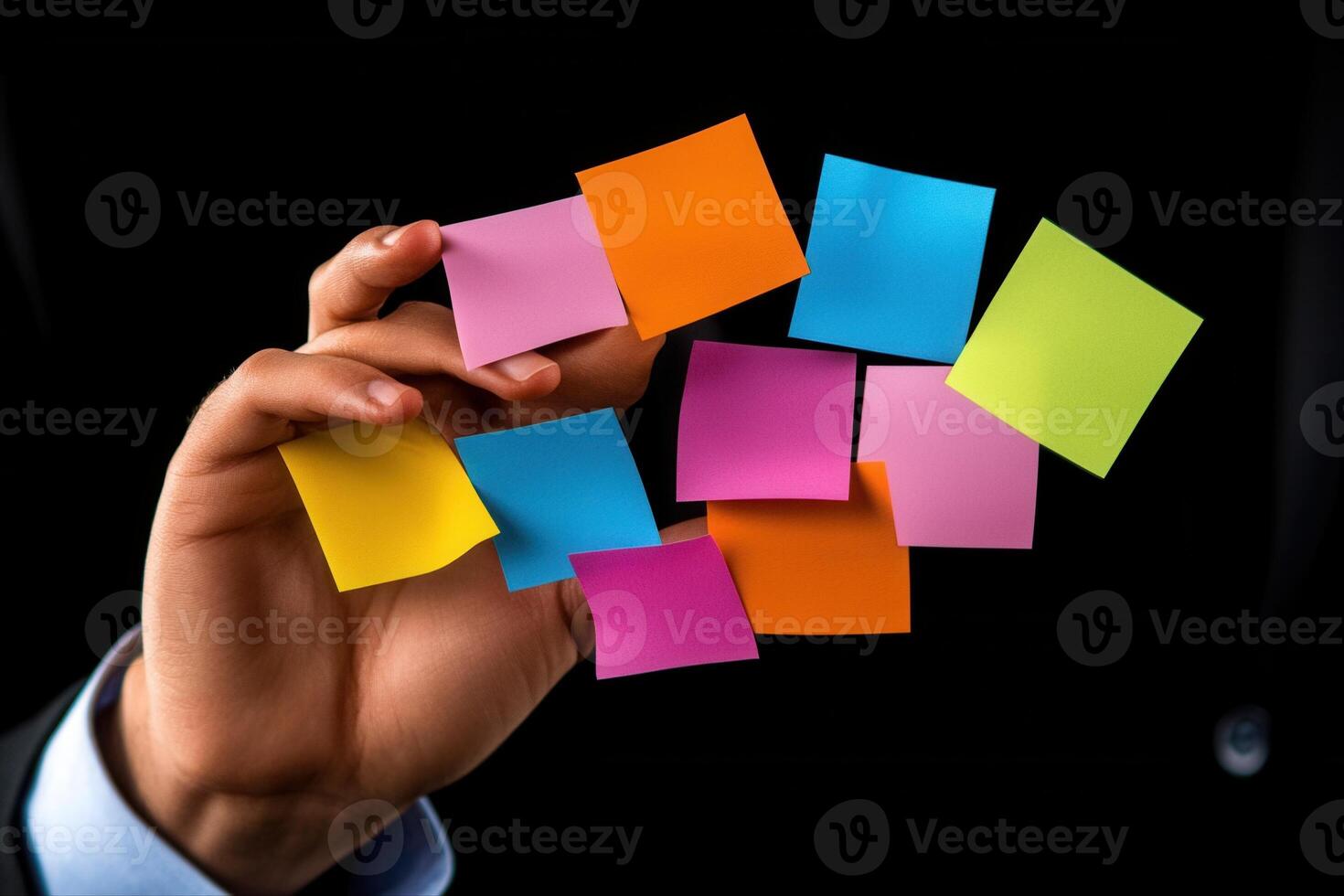 Person holding colorful sticky notes in a dark setting, showcasing organization and creativity photo