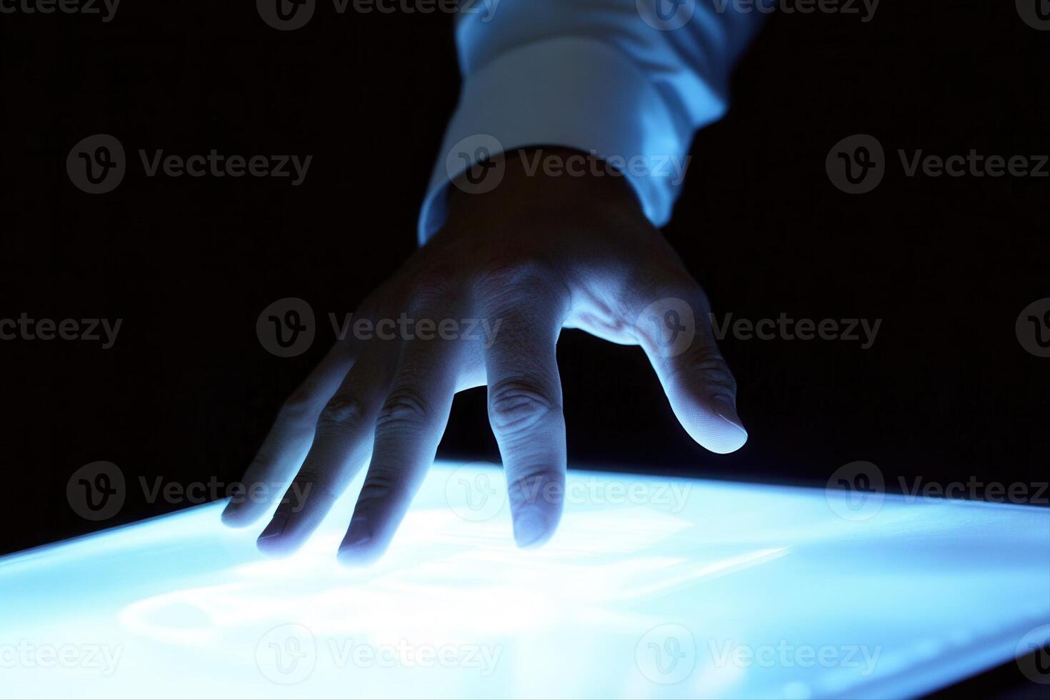 Human hand interacting with a glowing touchscreen in a dark environment, showcasing technology photo