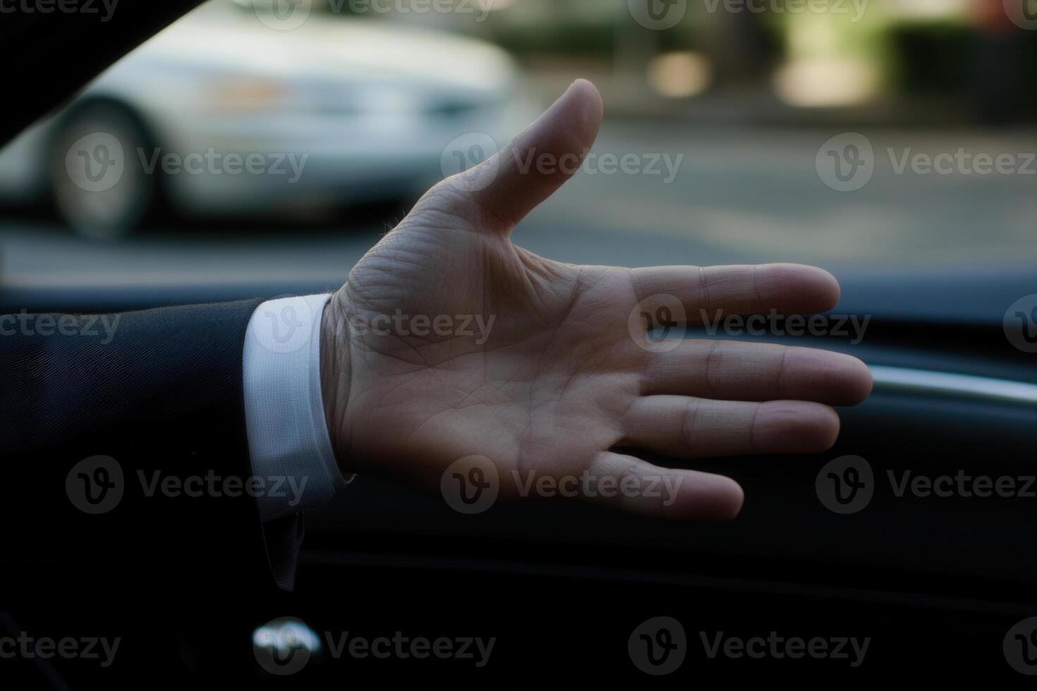 Hand reaching out of a car window, signaling for attention in a busy urban street photo