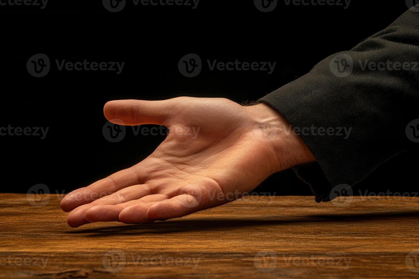 Outstretched hand reaching for assistance on a wooden table against a dark background photo
