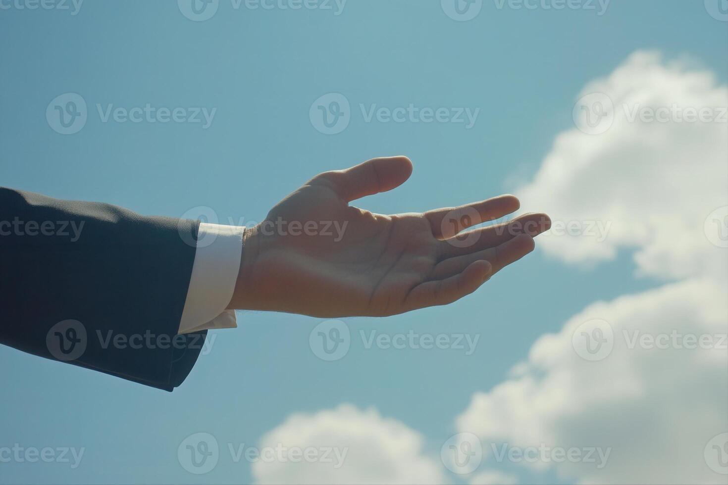Outstretched hand in a suit against a bright blue sky with fluffy clouds, symbolizing hope photo