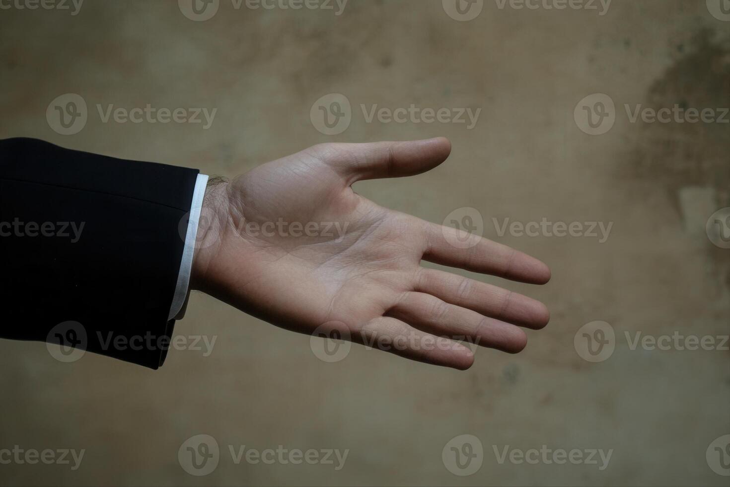 Open hand gesture against a textured background, symbolizing greeting or offering help photo