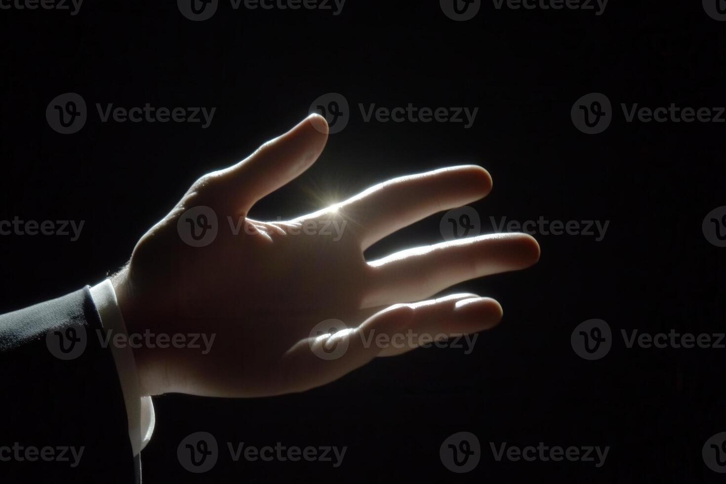 Illuminated hand reaching out against a dark background, symbolizing connection and hope photo