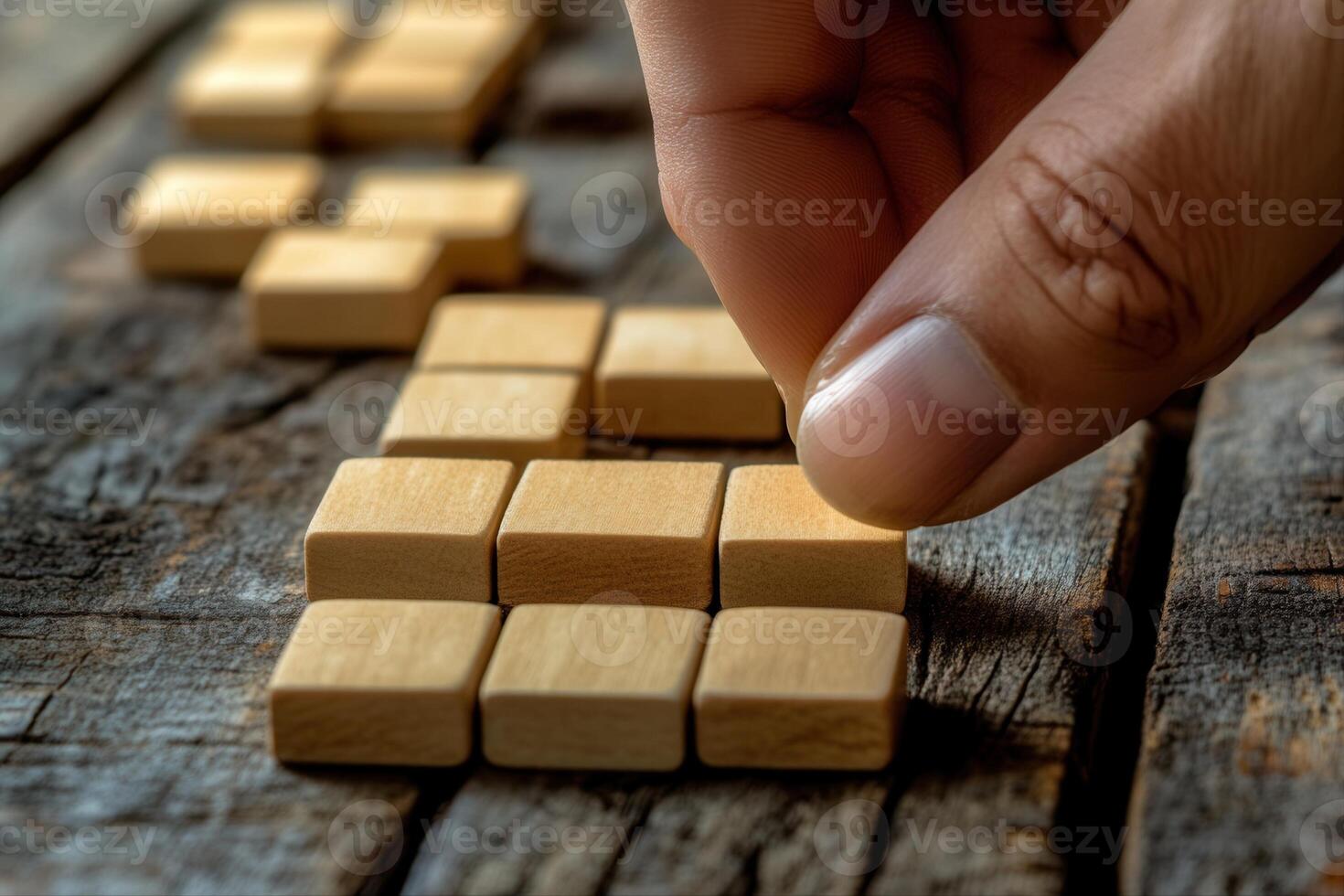 Hand arranging wooden blocks on a rustic table, showcasing creativity and focus in play photo