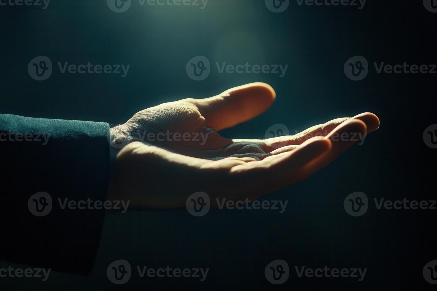 Open hand reaching out in soft light, symbolizing hope and connection in a dark setting photo