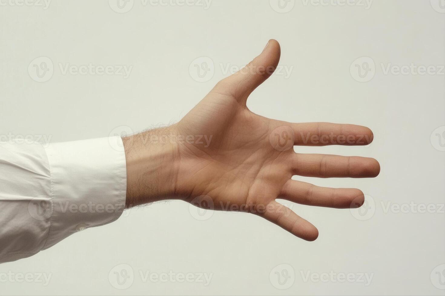 Outstretched hand in a formal shirt reaching forward against a neutral background photo