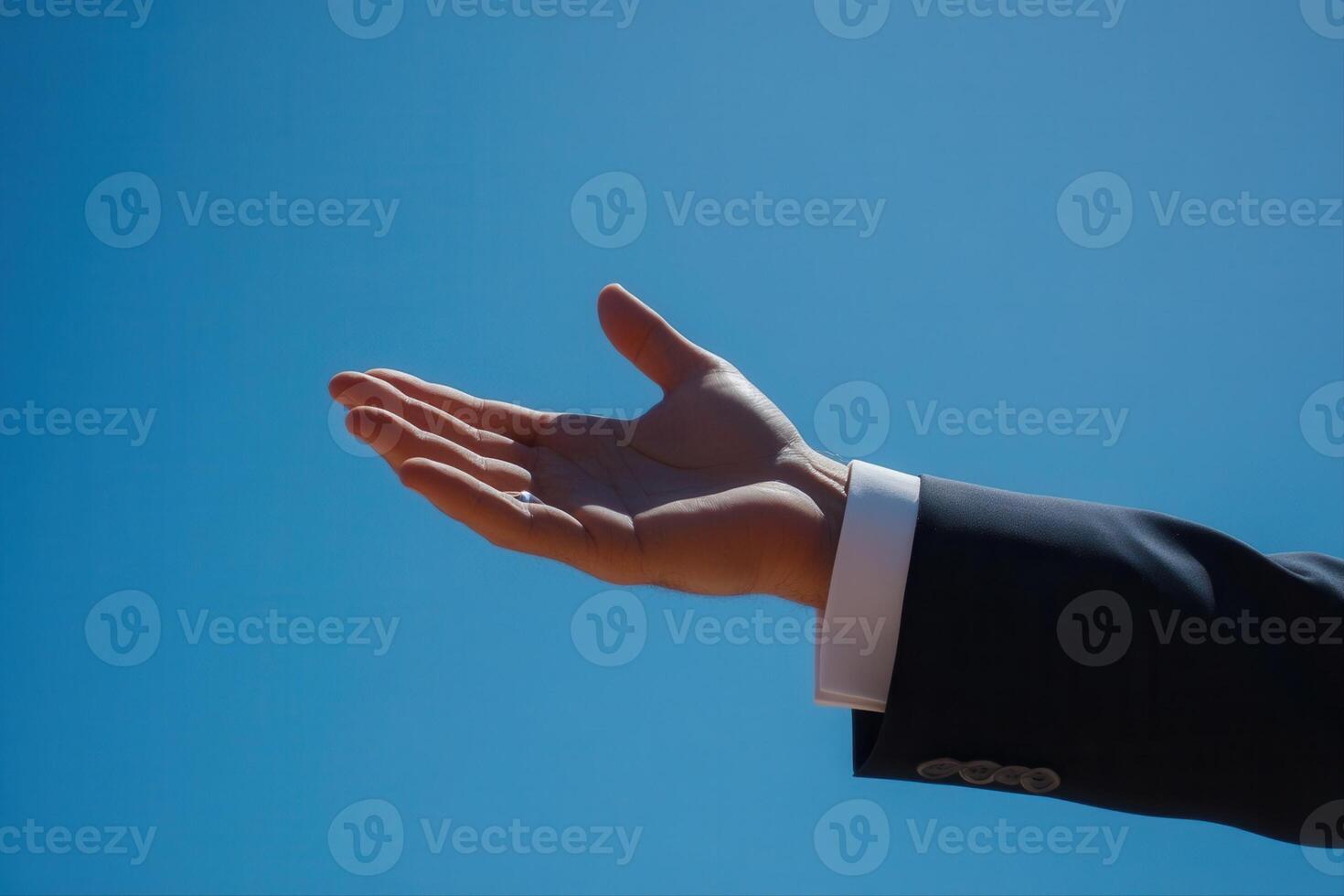Outstretched hand against a clear blue sky, symbolizing openness and invitation photo