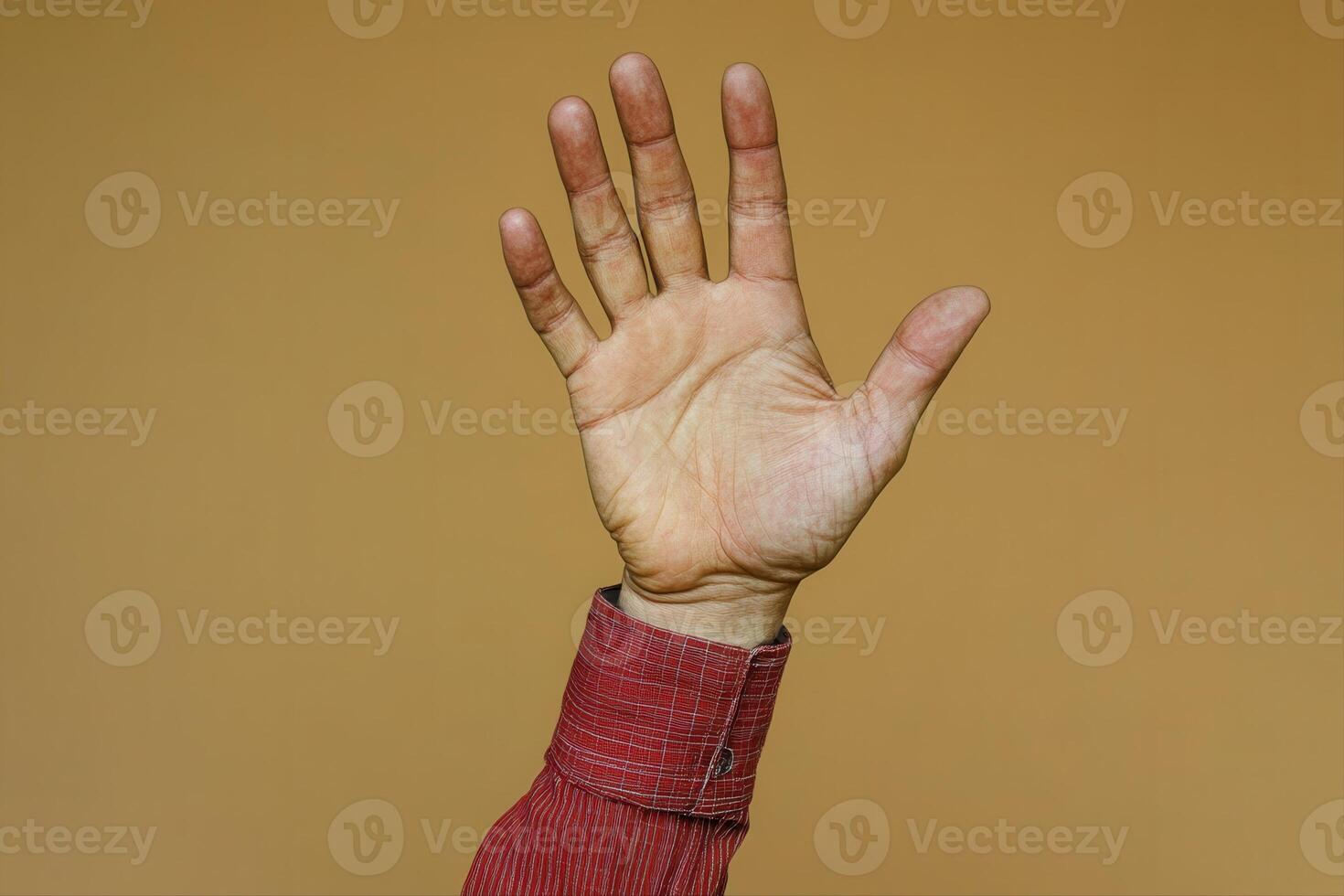 Hand raised in greeting against a warm, neutral background, symbolizing connection and communication photo