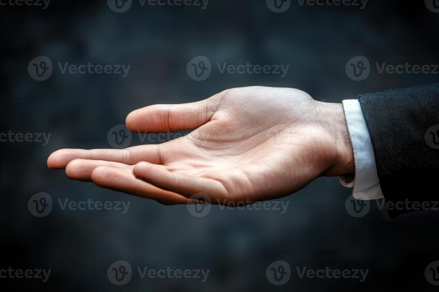 Open hand gesture in business attire against a blurred dark background, symbolizing invitation photo