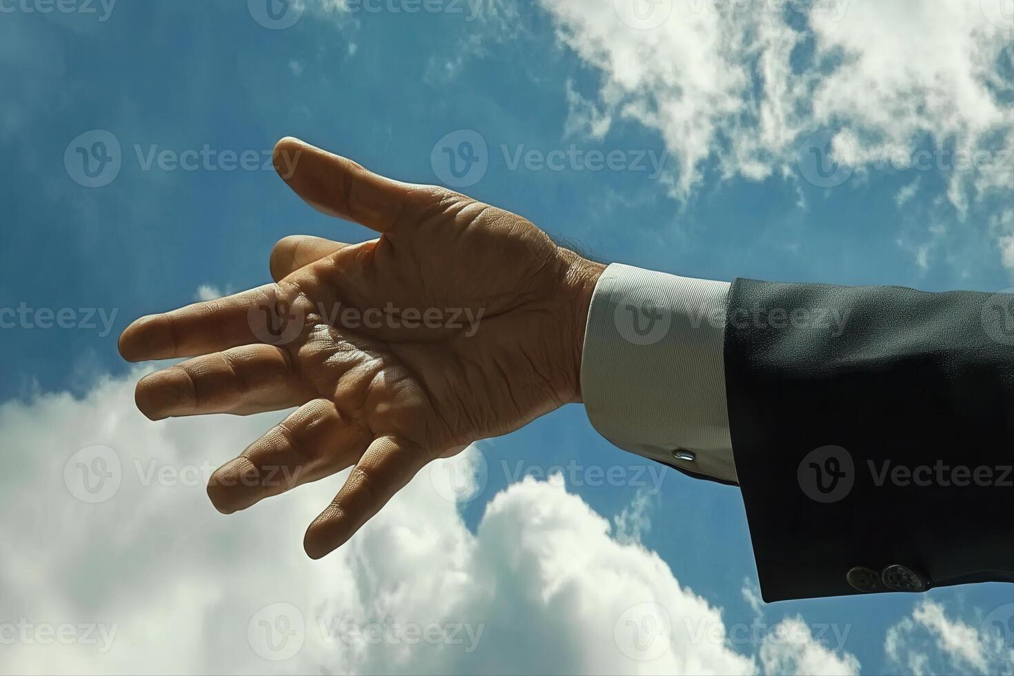 Outstretched hand reaching towards the sky, framed by clouds, symbolizing aspiration photo