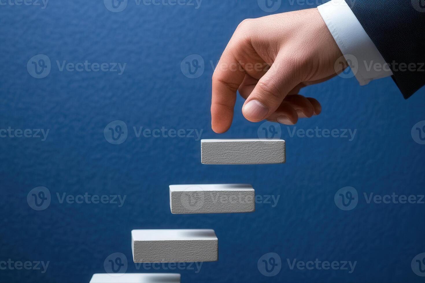 Hand reaching for ascending blocks against a blue background, symbolizing progress and achievement photo