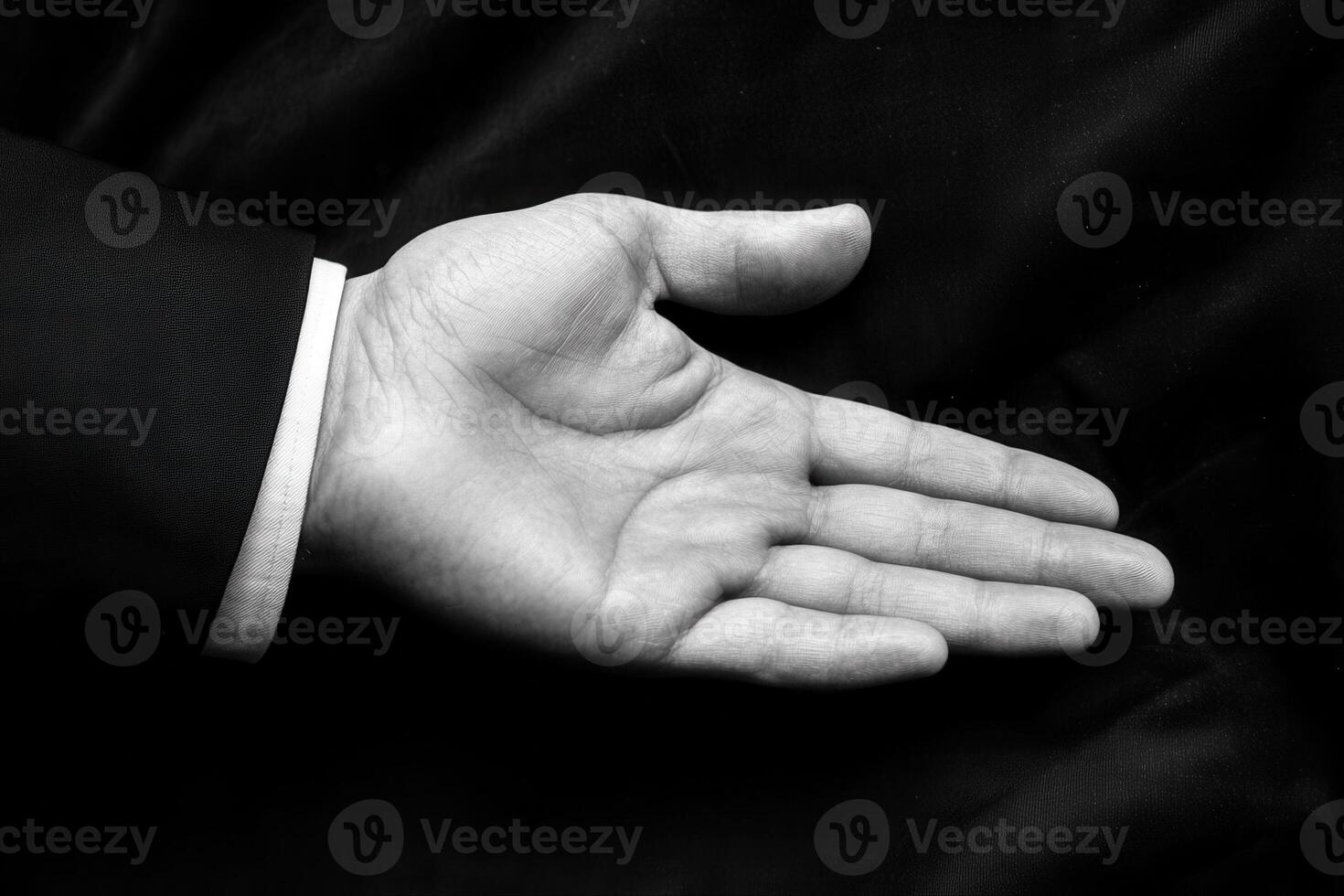 Open hand of a business professional against a dark background, symbolizing readiness photo