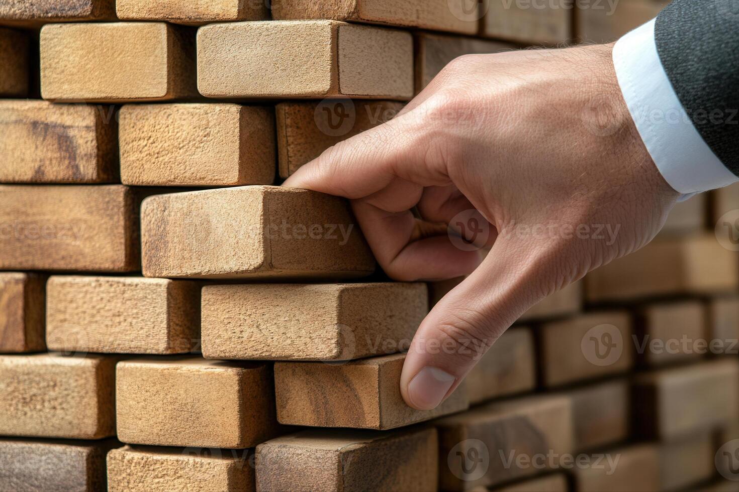 Hand carefully removing a block from a wooden tower game in a well-lit indoor setting photo