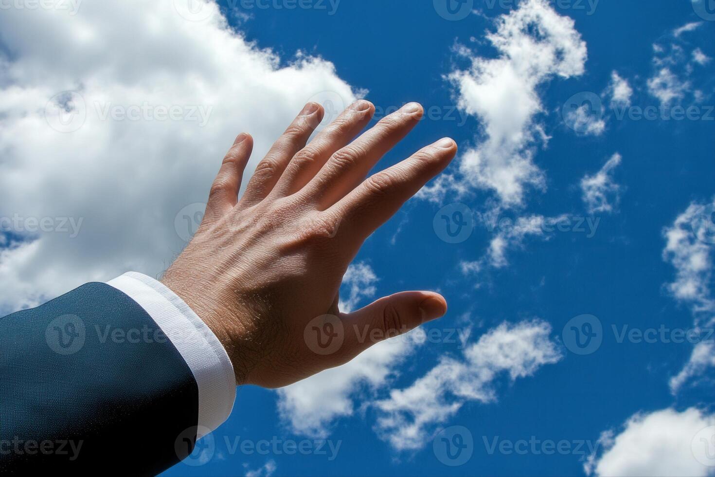 Reaching for the Sky A Businessman Extends His Hand Towards a Bright Blue Sky with Clouds photo