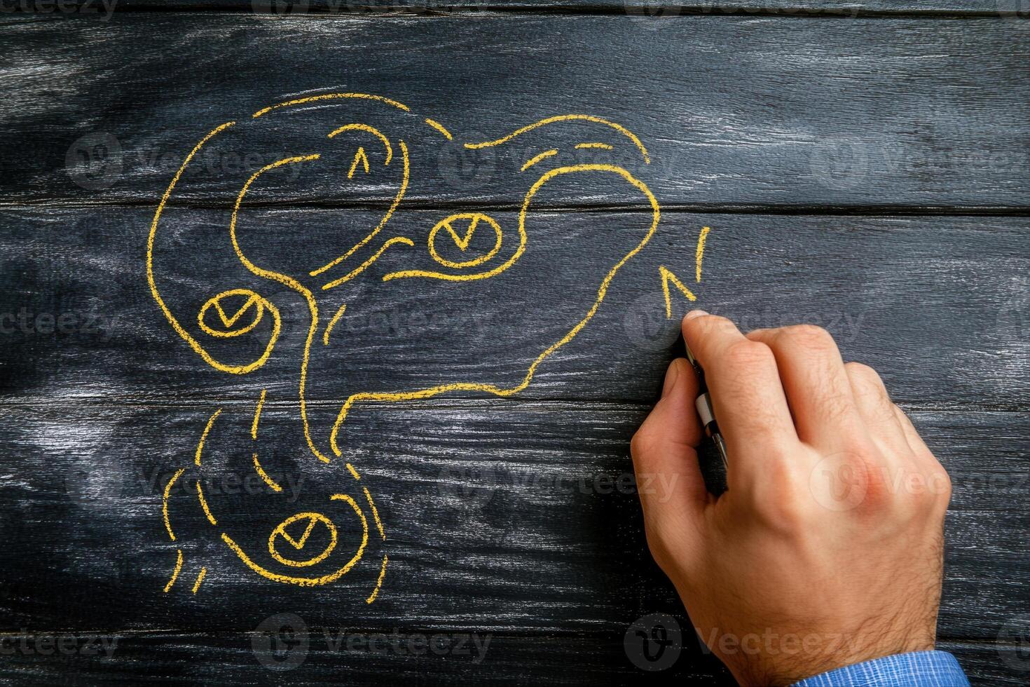 Hand drawing a creative map with yellow chalk on a rustic wooden surface, illustrating routes photo