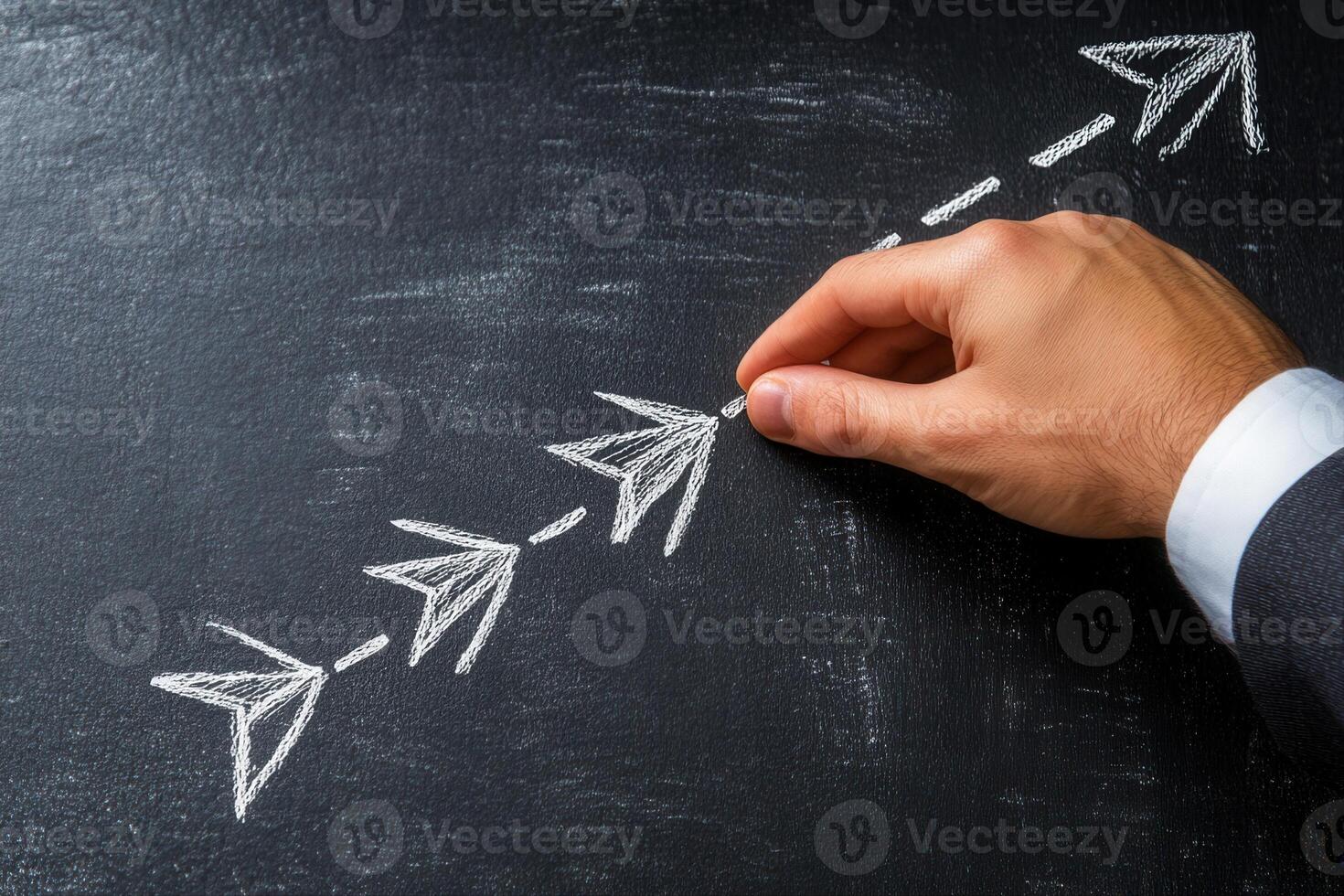 Hand drawing arrows on a chalkboard, illustrating progress and direction in business strategy photo