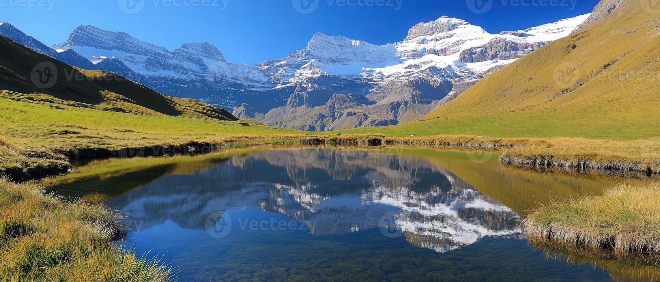 Alpine lake reflects snow-capped peaks photo