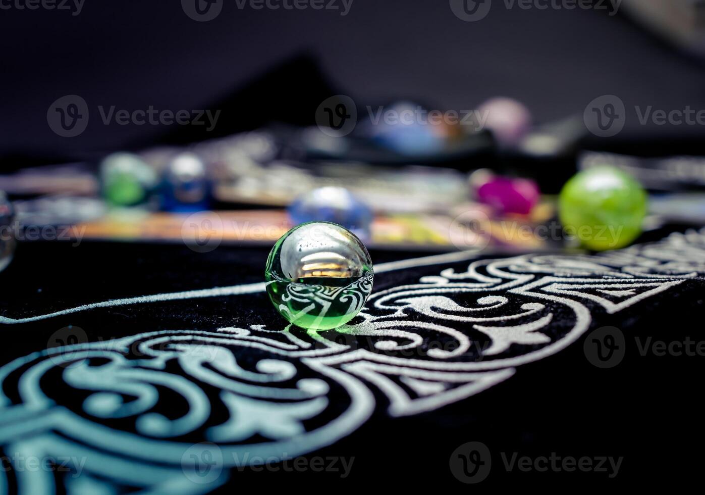 Single transparent marble surrounded by others on soft fabric photo