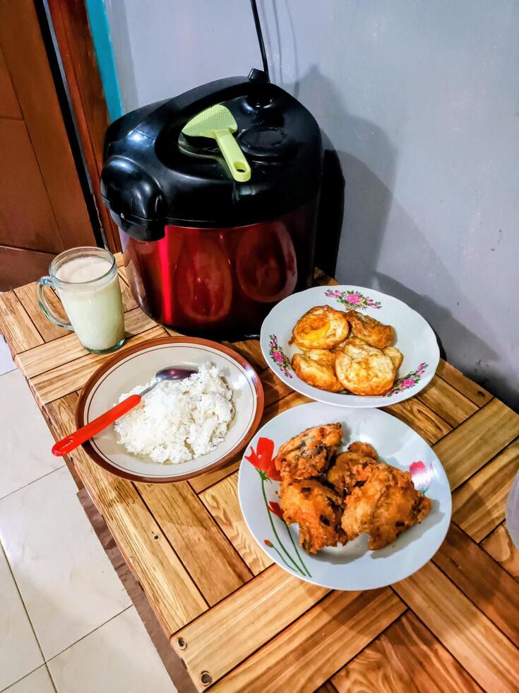 Simple Meal with Rice, Fried Chicken, Eggs, and a Drink photo