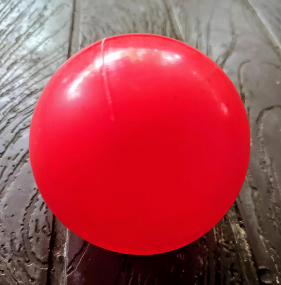 Red Contact Juggling Ball on a Dark Surface photo
