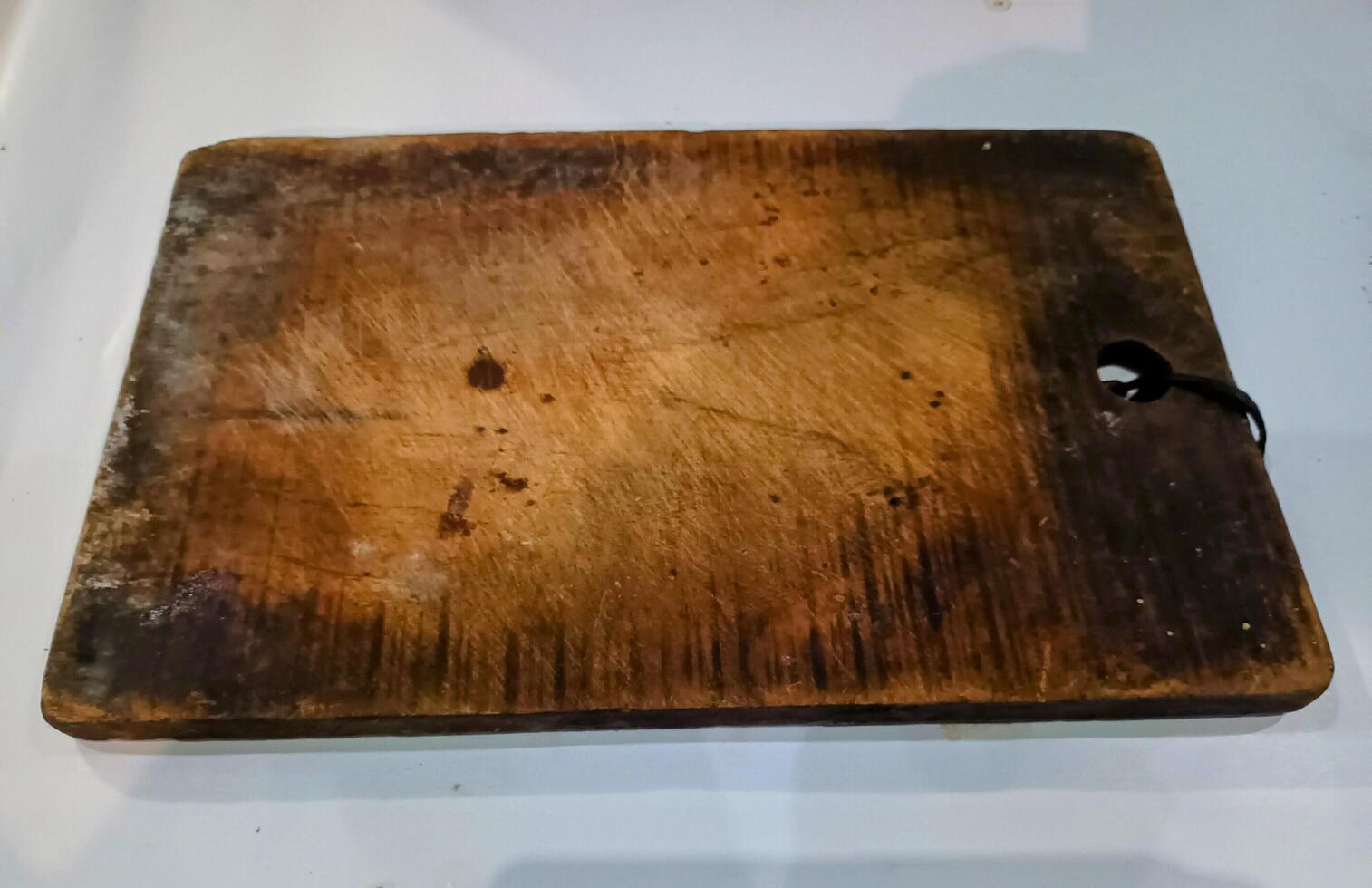 Used Wooden Cutting Board on a White Surface photo